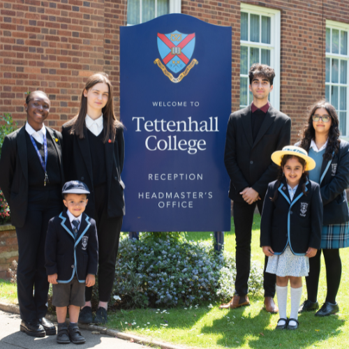 students stood by the sign for their school